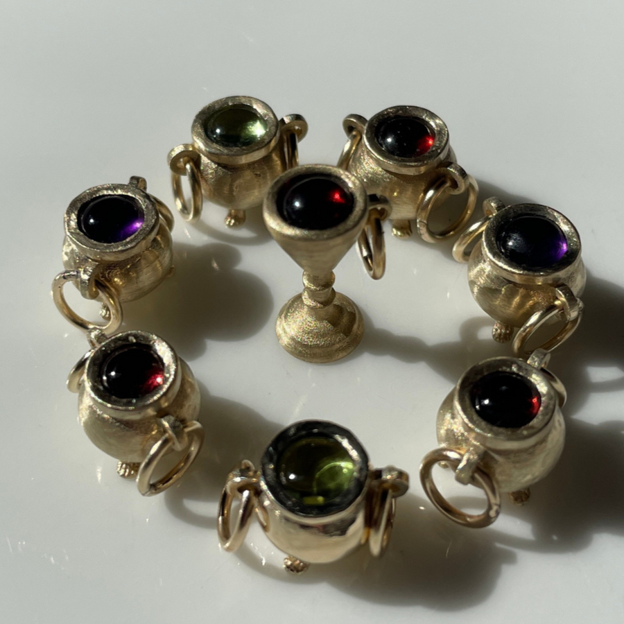 Gold cauldron charms surrounded by a gold goblet charm.