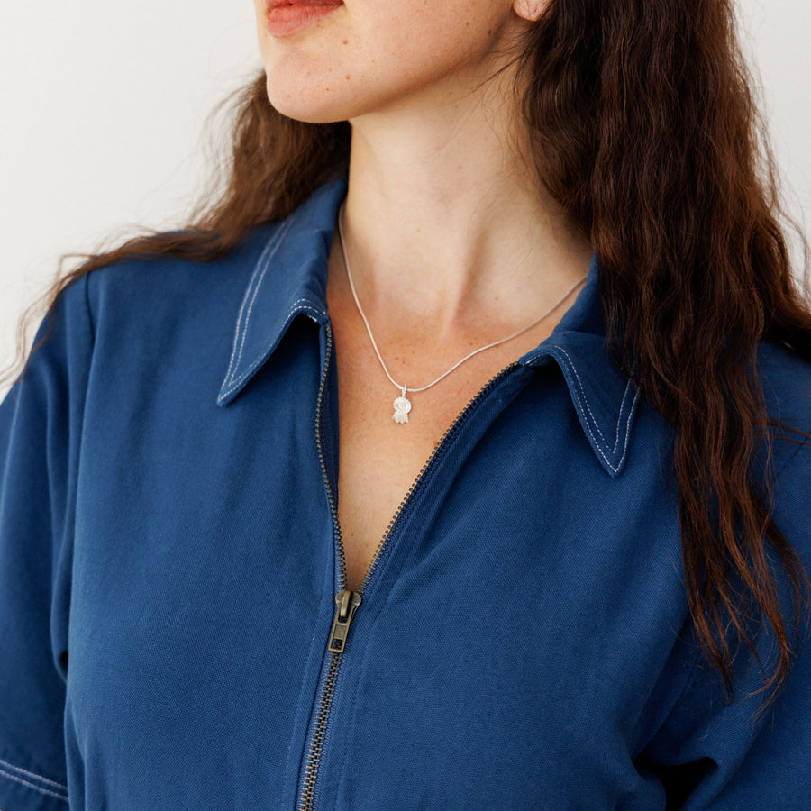 Woman wearing a blue shirt with a neutral background