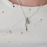 Necklace with a star pendant worn by a person on a white waffle shirt