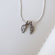 Necklace with two heart charms on a white surface