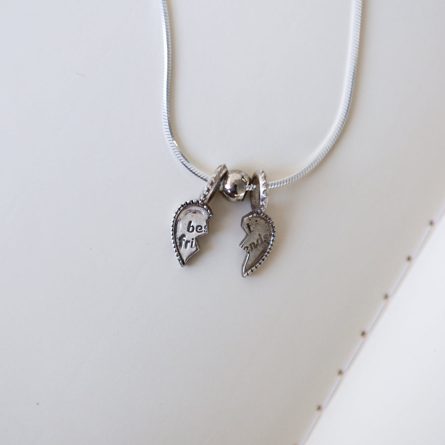 Necklace with two heart charms on a white surface