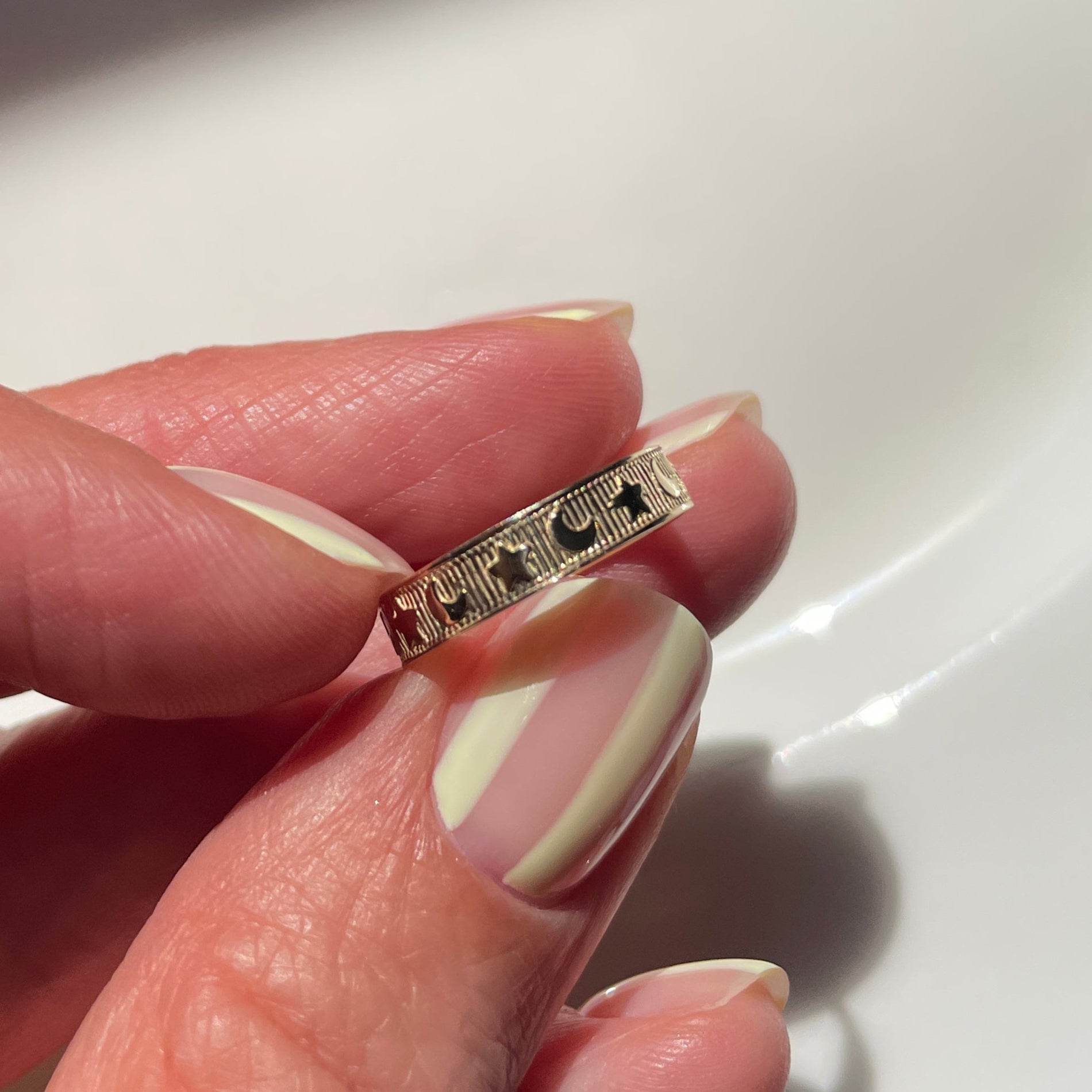 Hand holding a ring with a white background