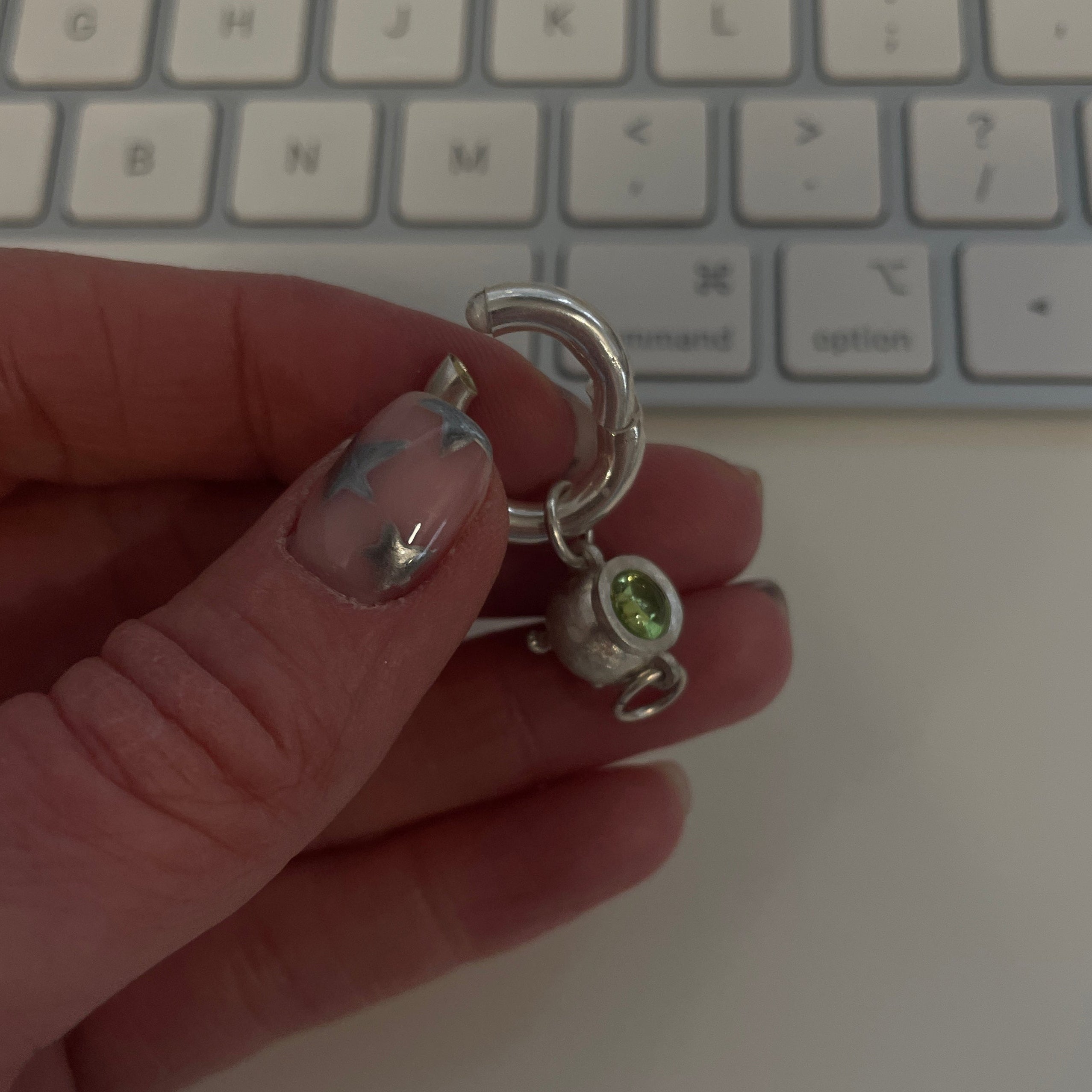 Sterling silver cauldron charm being held