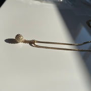 Necklace with a small pendant on a light gray background