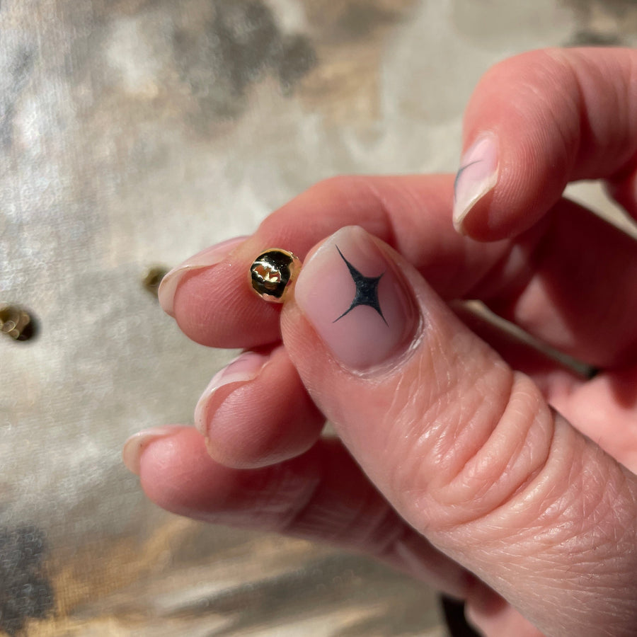 Hand holding a gold bat spacer bead