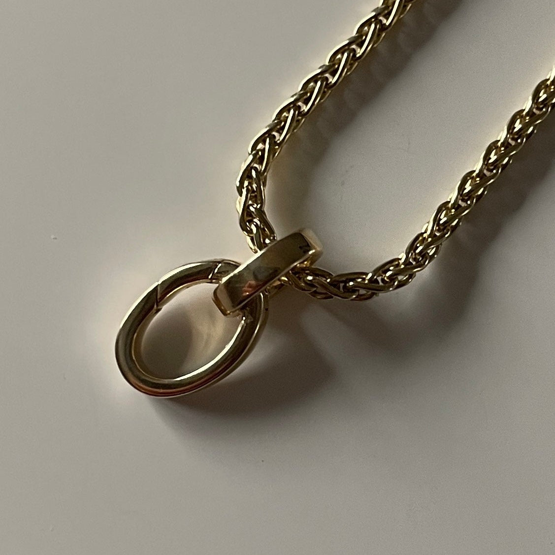 Gold chain necklace on a light gray background