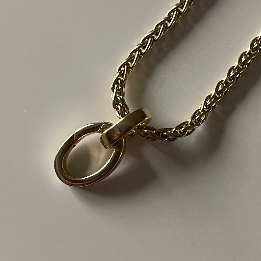 Gold chain necklace on a light gray background